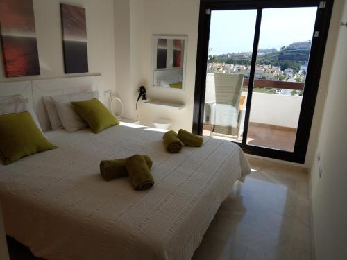 1 dormitorio con 1 cama blanca grande y toallas. en Lets in the Sun Calablanca, en La Cala de Mijas