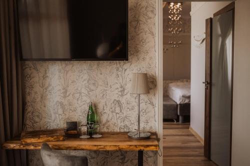 Pokój ze stołem i telewizorem na ścianie w obiekcie Winny Dworek w mieście Sulechów