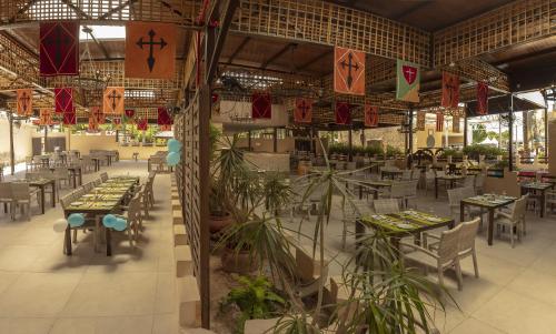 a restaurant with tables and chairs and plants at Magic Robin Hood in Albir