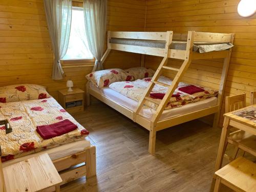 a bedroom with two bunk beds and a window at Chata pri jazere - 6km od Slovakia Ringu in Horná Potôň