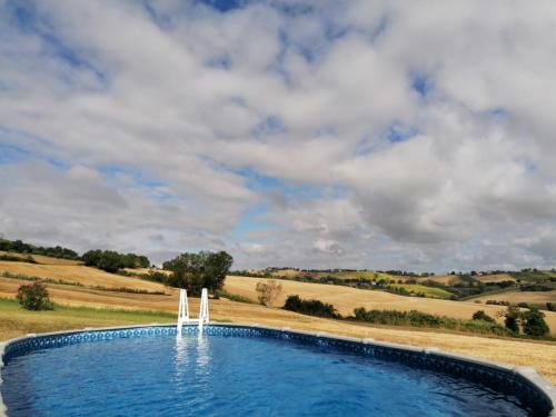 una piscina en medio de un campo en Il Giardino nella Valle, en Belvedere Ostrense