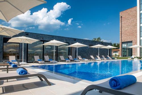 a swimming pool with chairs and umbrellas at Villa Mosavali in Akhalubani