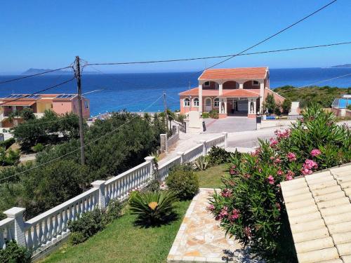 a house on a hill with the ocean in the background at spiros maria studios in Corfu Town