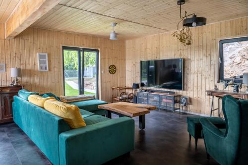 een woonkamer met blauwe banken en een tv bij Houses with a View#Sauna#Jaccuzi in Gozdowice