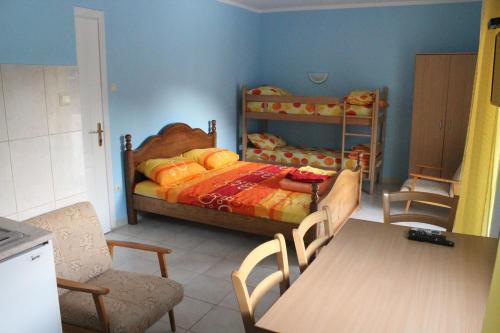 a bedroom with a bed and a table and chairs at Vila AKI-KA in Sutomore