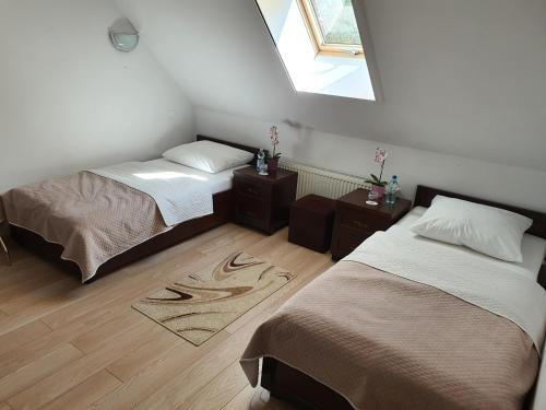 a bedroom with two beds and a window at GOŚCINIEC NAD NARWIĄ - Airport Modlin in Kikoły