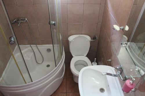 a bathroom with a toilet and a tub and a sink at Vila AKI-KA in Sutomore
