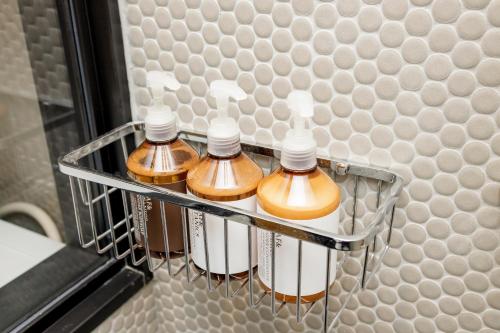 4 bottiglie di sapone in un appendiabiti in bagno di tefu yoyogi uehara 101 a Tokyo