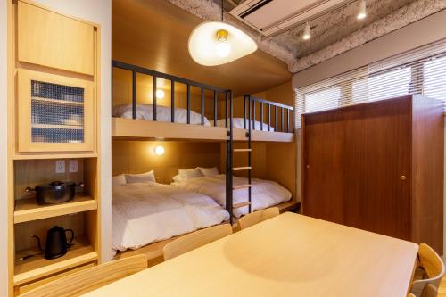a bedroom with two bunk beds and a table at tefu yoyogi uehara 101 in Tokyo