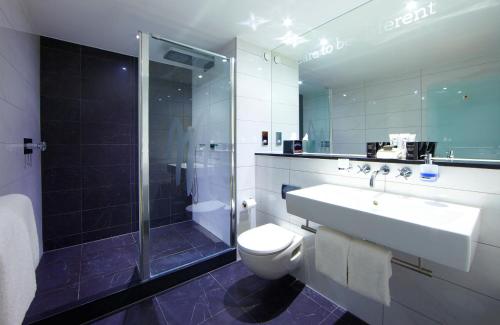 a bathroom with a sink and a toilet and a shower at Malmaison London in London