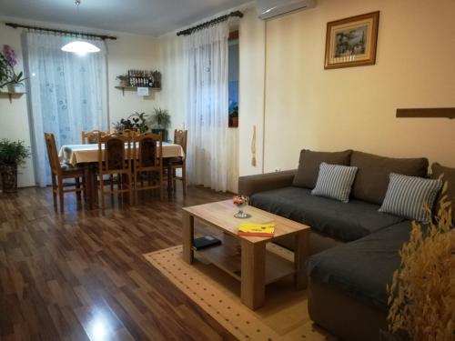 een woonkamer met een bank en een tafel bij Apartman Rosa in Skradin