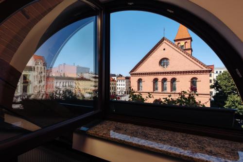 a view of a church from a window at Hotel Legenda in Toruń