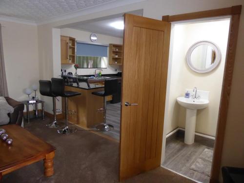 a room with a kitchen with a sink and a door at Glennydd House in Llangefni