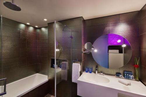 a bathroom with a tub and a sink and a mirror at Royal Beach Hotel Tel Aviv by Isrotel Exclusive in Tel Aviv