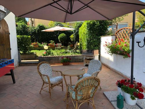 een patio met een tafel en stoelen en een parasol bij La terrazza di Elena in Abbadia San Salvatore