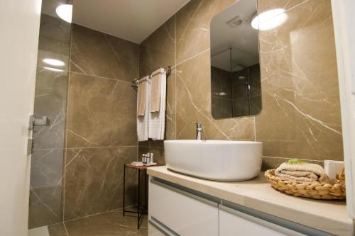 La salle de bains est pourvue d'un lavabo et d'un miroir. dans l'établissement Phaedrus Living: Seaside Luxury Flat Limnaria 152, à Paphos