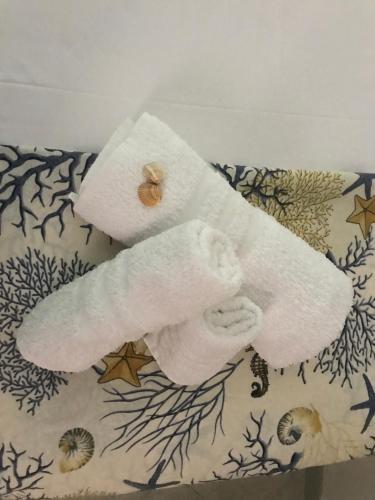 twee gevouwen handdoeken bovenop een kussen bij Apartment La Conchiglia in Menfi