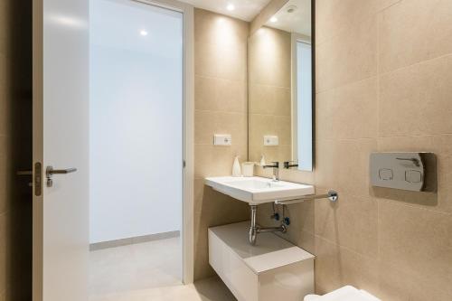 y baño con lavabo y espejo. en ApartUP Denia Beachfront Deluxe, en Denia