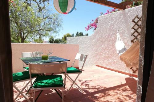 a table and chairs on a patio with a wall at Cozy Beach House in Pedras de El-Rei