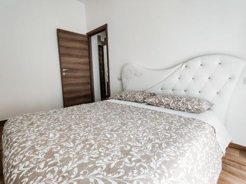 una camera da letto con un grande letto con copriletto e cuscini bianchi di Appartamento Stefano Laudi a Porto SantʼElpidio