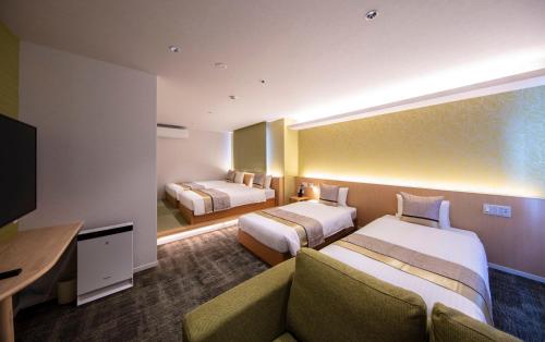 מיטה או מיטות בחדר ב-GRAND BASE Okayama Ekimae