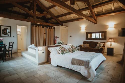 a bedroom with a large white bed and a couch at Masseria Baroni Nuovi in Brindisi