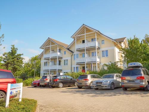 a large building with cars parked in a parking lot at Wohnpark Stadt Hamburg - Apt. 05 in Binz