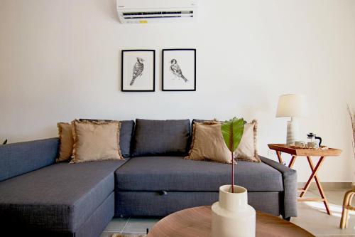 a living room with a blue couch and a table at Phaedrus Living Seaview Luxury Flat Limnaria 153 in Paphos City