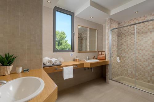 a bathroom with a tub and a sink and a shower at Ixian Hilltop Villa in Ialysos