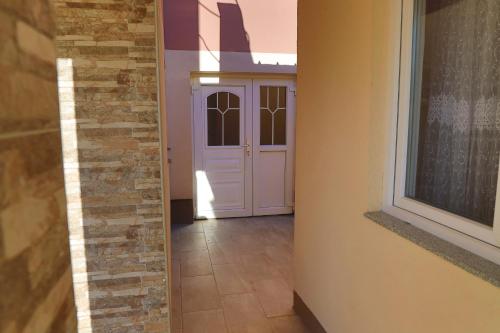 a hallway with a white door and a window at Apartment Vila Tara in Bihać