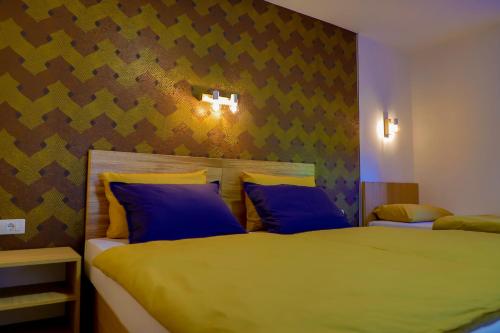 a bedroom with two beds with blue pillows at Apartment Vila Tara in Bihać