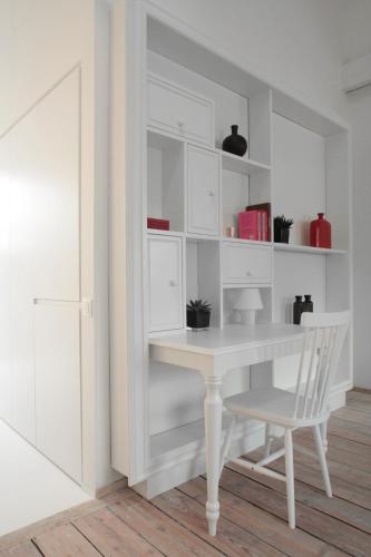 a white desk and a chair in a room at Maison Nationale City Flats & Suites in Antwerp