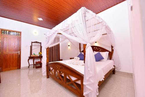 a bedroom with a bed with a canopy at Ariya Rest & Ayurveda spa in Polonnaruwa