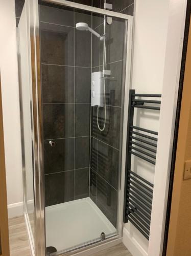 a shower with a glass door in a bathroom at Eastdene Guest House in Inverness