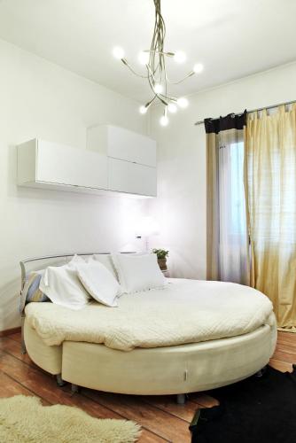 a bedroom with a large white bed with white pillows at Petite Suite in Bergamo
