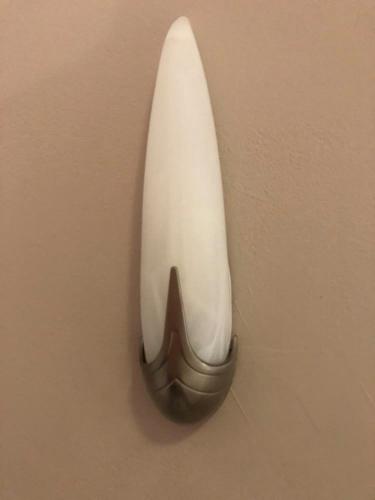 a wall mounted sconce on a wall with a white and brown at Akrogiali Hotel in Agios Sostis