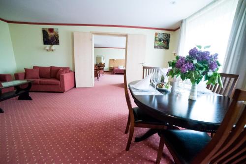 a living room with a table and a couch at Hotel Tigra in Priekuļi