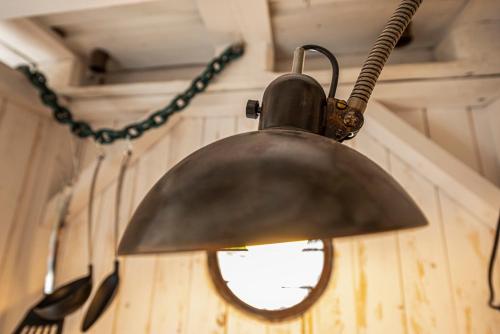 a metal bell hanging on a wall with utensils at Louse Puschen Manufaktur in Kiel