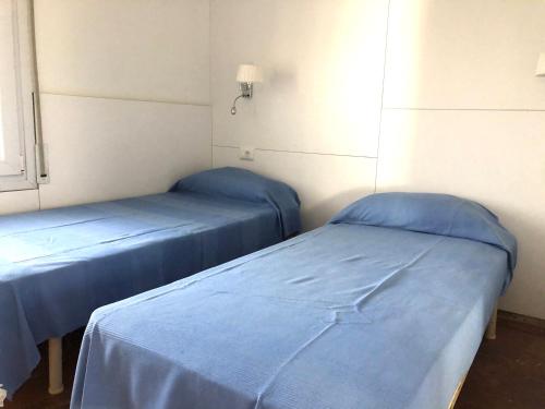 2 camas en una habitación de hospital con sábanas azules en PALMERAS - Apartamento en el centro de Roses - cerca de la playa - terraza - wifi, en Roses