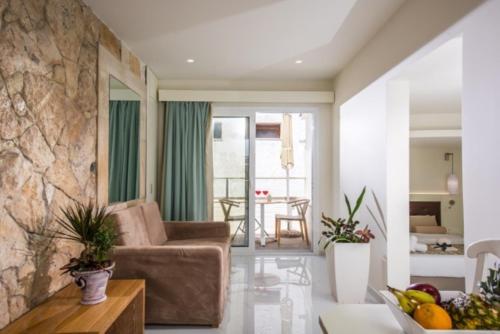 a living room with a couch and a table at Camelot Royal Beds by Estia in Malia