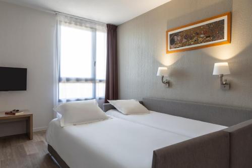 Кровать или кровати в номере Aparthotel Adagio Access Avignon