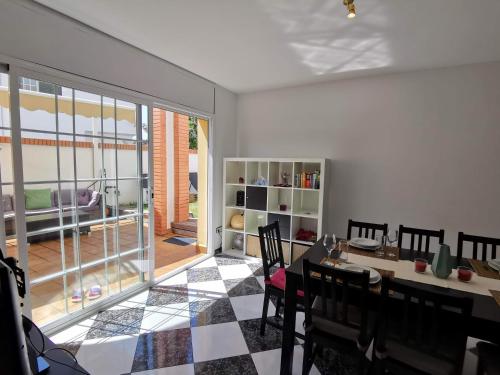 a dining room with a table and chairs and a glass door at Villa Arcos in Segur de Calafell