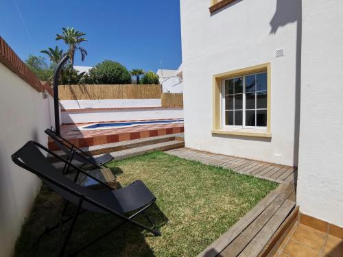 a yard with two chairs on the side of a house at Villa Arcos in Segur de Calafell