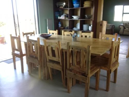 a wooden dining room table with wooden chairs and a table at Izulu Eco Lodge in Sodwana Bay
