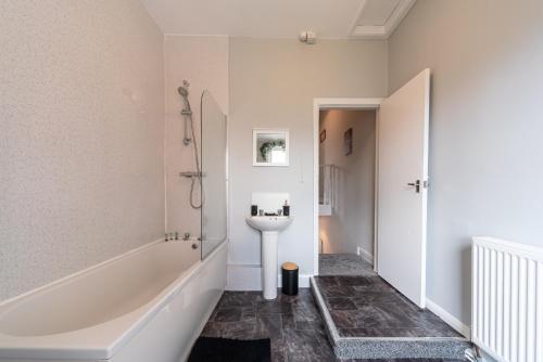 a bathroom with a bath tub and a sink at 3 Bedroom Hull Sleeps 6 Glam Contractor & Leisure & Families in Hull