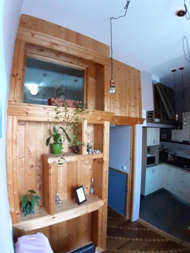 a kitchen with a wooden wall with a shelf at Apartament Mario in Sibiu
