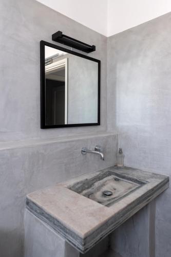 a bathroom with a sink with a mirror on the wall at Armenistis Apartment in Naousa