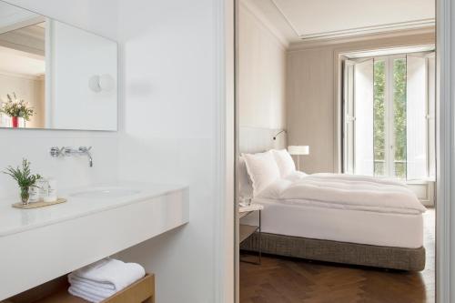a white bedroom with a bed and a mirror at Alma Barcelona GL in Barcelona