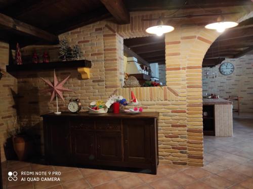 cocina con pared de ladrillo y encimera en una habitación en La taverna di lulu, en Arnesano