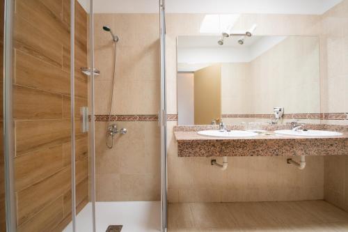 Un baño con dos lavabos y una ducha. en HL Club Playa Blanca, en Playa Blanca